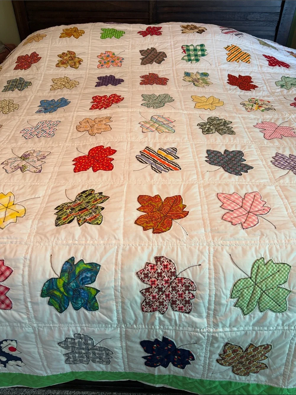 Vintage quilt handcrafted with color leaf blocks on white with green trim